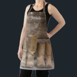 Delantal Oeste de Cowboy Boots Rústico Barn Monograma<br><div class="desc">Este divertido y rústico delantal cuenta con dos botas de vaquero y una pared de una cabaña de troncos con luces de cuerda. Para los occidentales o los amantes de los caballos. Lávatelo en la cocina o en el granero. Creado por Simply Farmhouse Press; foto de Melanie Mauer en Unsplash....</div>