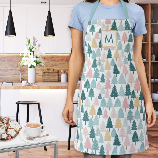 Delantal Pastel Navidades Pine Trees Cocina Monogramada (A monogrammed kitchen apron with festive Christmas trees pattern in teal, pink, yellow and white)