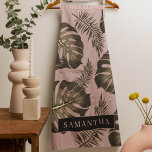 Delantal Patrón y nombre de hojas de palma rosadas y dorada<br><div class="desc">El diseño de las hojas de palma rosadas y doradas Tropical presenta un diseño vibrante y exótico inspirado en la estética tropical. Los colores predominan en los tonos rosa y dorado, creando un ambiente lujoso y de diseño. El patrón consiste en hojas de palma representadas en una variedad de tamaños...</div>