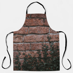 Delantal Plantas verdes cerca de la pared de ladrillos