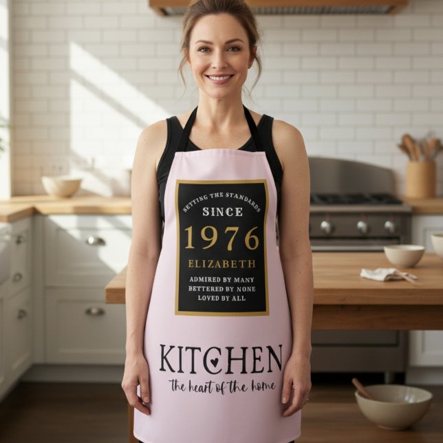 Delantal rosa personalizado para cumpleaños 50 (1976 birthday apron worn in a kitchen)