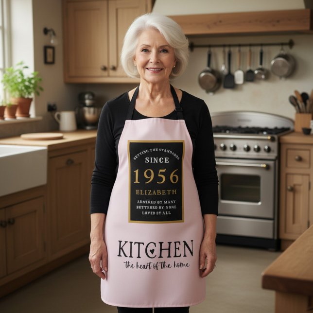 Delantal rosa personalizado para cumpleaños 70 (1956 birthday apron worn in a kitchen)