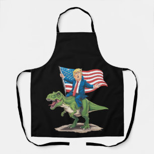 Delantal Trump montando dinosaurio T Rex bandera de EE. UU.