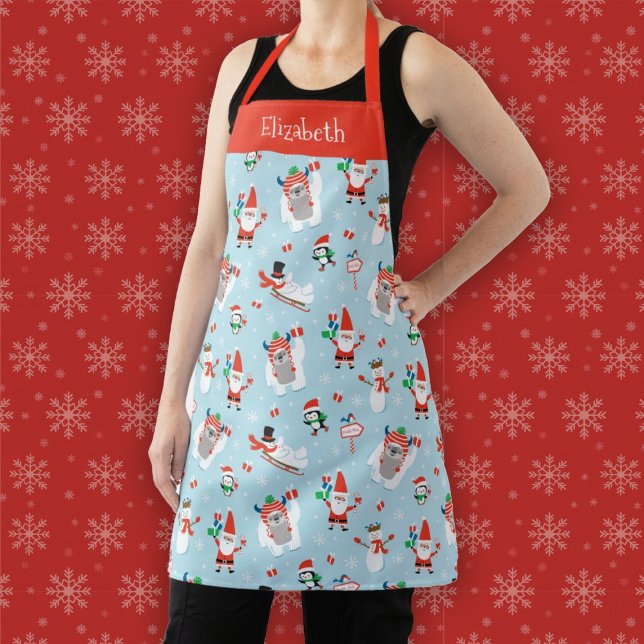 Delantal Vacaciones de Navidades de invierno personalizados (A fun winter Christmas holiday apron featuring Santa, a yeti, a snowman, and penguins)