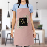 Delantal Verdor de color de agua rosada Rubor Monograma de<br><div class="desc">Elegante vegetación acuarela deja un monograma floral con un monograma dorado inicial sobre un fondo rosa rubor con su nombre en tipografía blanca moderna. Diseñado por Thisisnotme©</div>