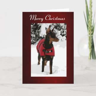 Doberman rojo en la tarjeta de Navidad de la nieve