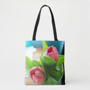 dos tulipanes rosados en una bolsa de té impresa e