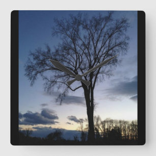 El árbol en el reloj de pared del crepúsculo