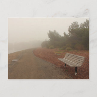 El banco de parques en la tarjeta postal de niebla