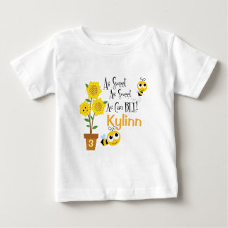 El bebé manosea la camiseta de la abeja
