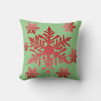 El copo de nieve rojo en el Cojín decorativo verde