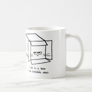 El gato enojado oculta en una caja - taza de café