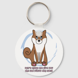 El perro triste observa el llavero de Shiba Inu