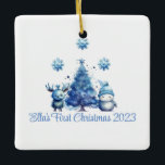 El primer ornamento azul de Navidad del bebé<br><div class="desc">Celebra la primera Navidad de tu bebé con adorables ilustraciones acuáticos de un reno azul y un muñeco de nieve frente a un hermoso árbol de Navidad azul. Personalizable para el nombre y la fecha de cualquier bebé.</div>