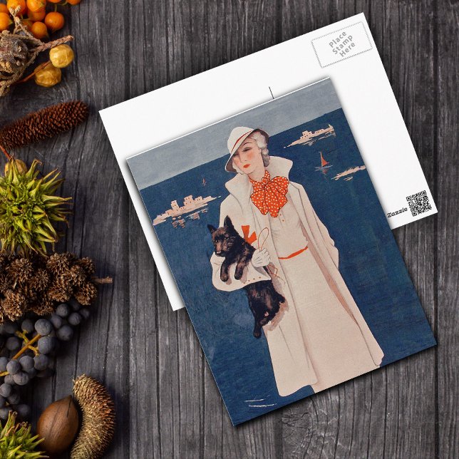 Elegante dama de la época con postal de perro esco (Elegant lady in white suit holding black scotty dog by ocean on postcard.)