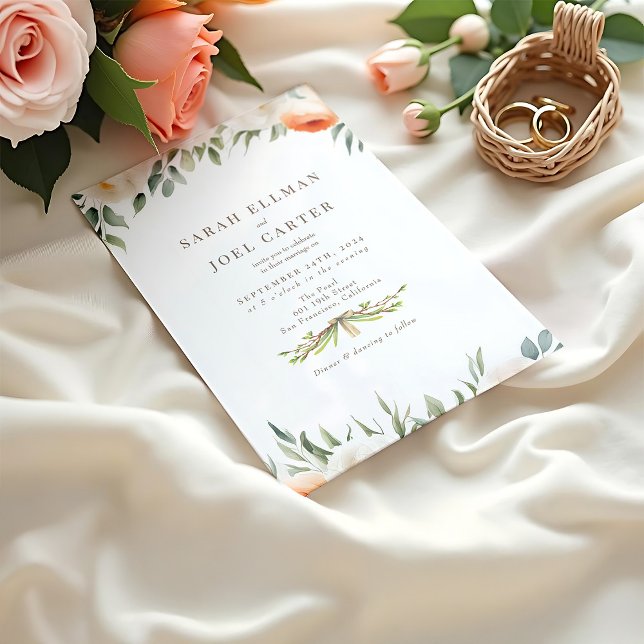 Elegante invitación a la boda botánica etérea (A peach toned wedding invitation mockup with floral details resting on a creamy fabric beside roses)