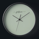 Elegante nombre de guión verde sabio reloj grande<br><div class="desc">Reloj moderno con un fondo verde sabio y un nombre de guión de gaviota negro con letras a mano. Personaliza con tu nombre</div>