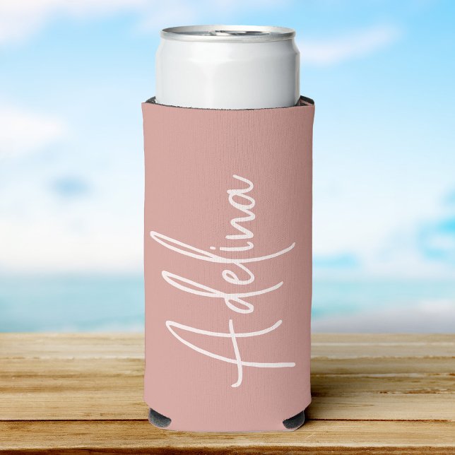 Enfriador De Latas Slim Script Estiloso Nombre Personalizado Chicas Viaje  (A blush can cooler with a custom name  in elegant white script, set against a soft beach background)