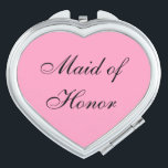 Espejo compacto de doncella de honor<br><div class="desc">Espejo compacto mostrado en forma de corazón con un color de fondo rosado con texto de doncella de honor en negro. Personalizar este artículo o compra tal cual.</div>
