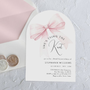 Está atando la invitación a la ducha de novias del