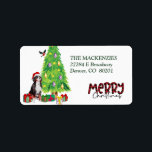 Etiqueta Bernese Mountain Dog Christmas Tree Return Address<br><div class="desc">En estas etiquetas de dirección de retorno hay una imagen de un Perro de Montaña de Berna con un sombrero de Santa rojo y blanco. El perro se sienta entre paquetes de regalo envueltos de colores junto a un árbol de Navidad decorado. Un pájaro bullfinch está aterrizando en el árbol...</div>