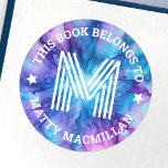 Etiqueta inicial del libro para niños morados azul<br><div class="desc">Etiquetas de placa con tu monograma inicial y texto de personalizable "este libro pertenece" y tu nombre en un fondo de patrón azul y púrpura.</div>