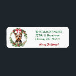 Etiqueta Merry Christmas Wreath Yorkie Return Address<br><div class="desc">En esta etiqueta de dirección de regreso de vacaciones, un adorable perro de Yorkshire Terrier está enmarcado dentro de una corona de Navidades verdes con un arco rojo en la parte superior. El texto de su personalizado está en verde a la derecha, con un campo de texto para un saludo...</div>