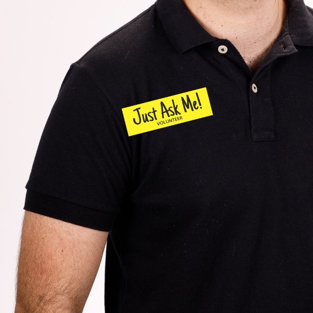 Etiqueta Para Nombres Voluntario amarillo me pregunta simple (Man wearing black shirt with yellow "just ask me" volunteer name tag badge.)
