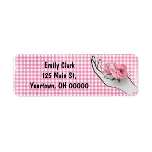 Etiqueta rosa rosa en mano sobre gingham
