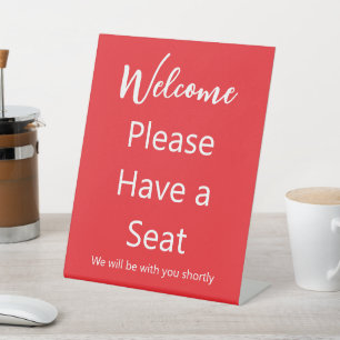 Expositor En L Bienvenida Por favor ten un asiento de texto rojo