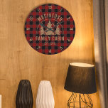 Familia Cabina Nombre Búfalo Rojo Tapado Reloj Gra<br><div class="desc">Crea un reloj de pared redondo personalizado, conmemorativo, con un diseño rústico de manta de búfalo rojo y negro y una imagen de pinos boscosos en el bosque con tu texto personalizado en castaño (mostrado con NOMBRE DE CABIN FAMILIA y fecha fijada para el año). Todo el texto es editable....</div>