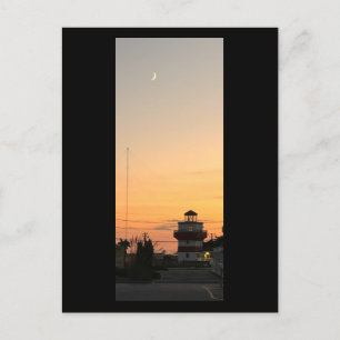 Faro al atardecer con postal lunar