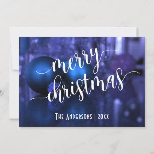 Feliz Navidad con bolas de vidrio azules y moradas
