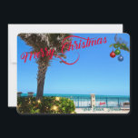 Feliz Navidad desde Vero Beach Florida Oceanfront<br><div class="desc">¡Feliz Navidad desde Vero Beach, Florida! Esta colorida tarjeta de bienvenida de temática tropical presenta una imagen fotográfica de una hermosa zona frente al mar de Vero Beach decorada para las vacaciones. El diseño festivo incluye Navidades iluminados por la vegetación, bolas de Navidad colgadas de un frontón de palma y...</div>