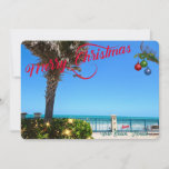 Feliz Navidad desde Vero Beach Florida Oceanfront<br><div class="desc">¡Feliz Navidad desde Vero Beach, Florida! Esta colorida tarjeta de bienvenida de temática tropical presenta una imagen fotográfica de una hermosa zona frente al mar de Vero Beach decorada para las vacaciones. El diseño festivo incluye Navidades iluminados por la vegetación, bolas de Navidad colgadas de un frontón de palma y...</div>