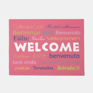 Felpudo Bienvenido a muchos idiomas Doormat de fondo rosad