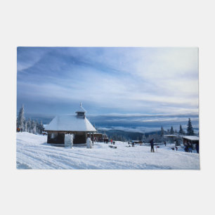 Felpudo Capilla en la montaña de la nieve de los Alpes