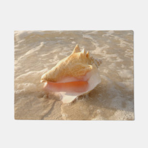 Felpudo Concha Shell en arena en la playa tropical