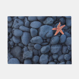 Felpudo Estrellas de mar en rocas negras a lo largo de la