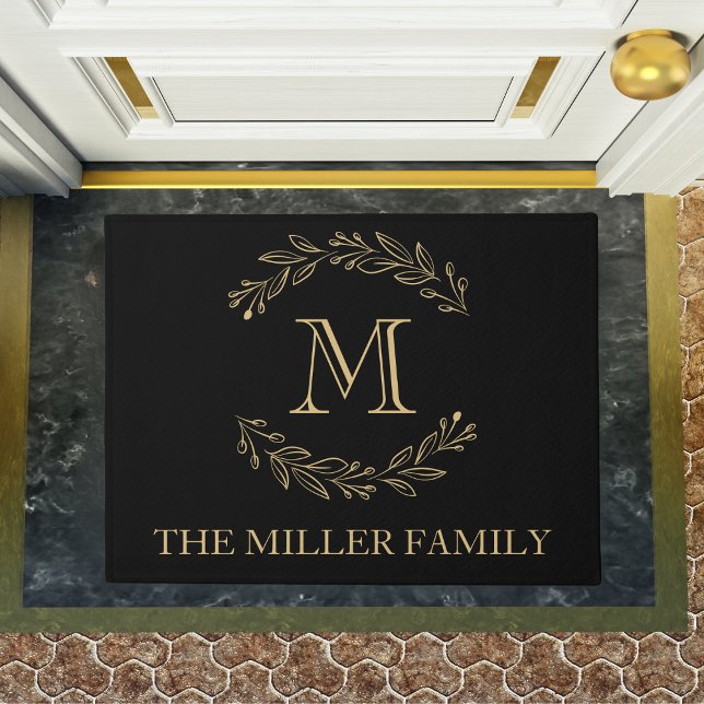 Felpudo Monograma elegante de la familia de guirnaldas de  (Elegant Black Gold Wreath Family Name Monogram Doormat)
