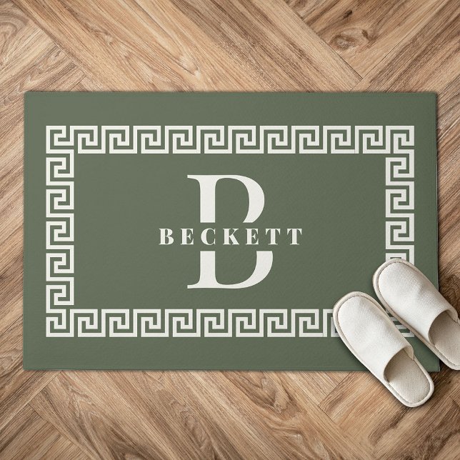 Felpudo Monograma elegante moderno con clave griega de sab (Green doormat with Greek key border design, featuring a large letter "B" over the name "Beckett." )