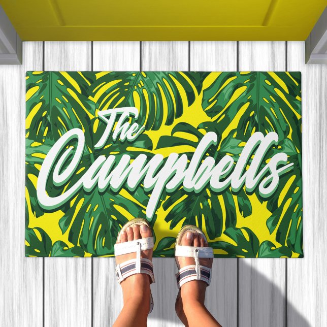 Felpudo Nombre de familia tropical hojas de monastera amar (Doormat with pattern of green palm leaves on yellow background. Text overlay says your family name)