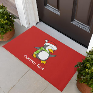 Felpudo pingüino de Navidad caminando sobre la nieve