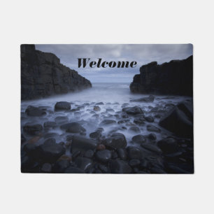 Felpudo Rocas y guijarros a lo largo de la orilla costera