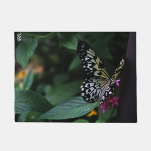 Felpudo Una mariposa amarilla sobre flores rosadas