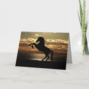 Festiva tarjeta de saludo de caballos de la puesta del sol