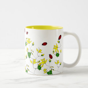 Flores amarillas y pequeña taza de las mariquitas