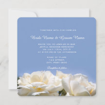 flores blancas de rosa en invitación de boda azul