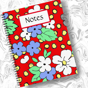 Flores blancas y azules en cuaderno de espiral roj
