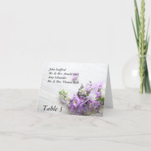 flores en tonos lavanda con tarjeta de mesa de mús